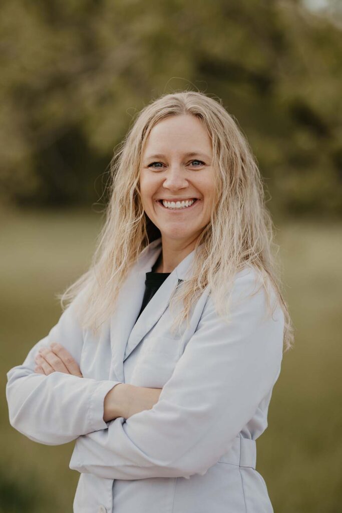Dr. Allison Jung smiling outdoors in a white coat