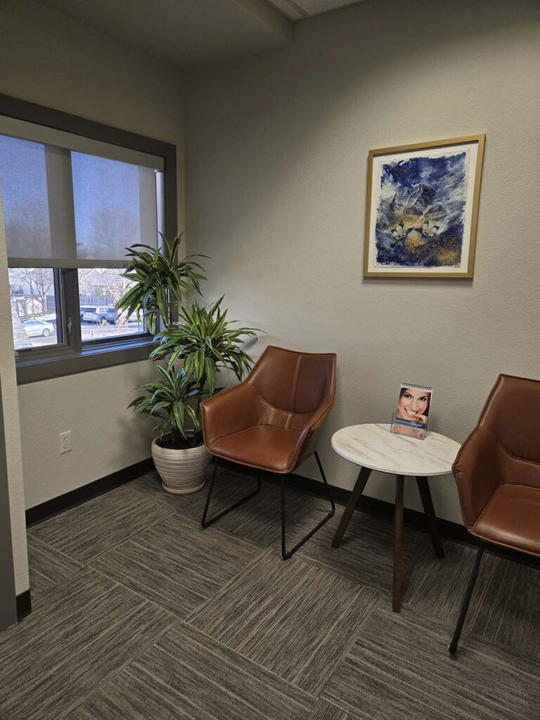 Patient waiting area with a plant and chairs at Allison Jung Family Dentistry