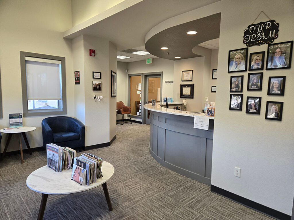 Reception desk and waiting area with team photos at Allison Jung Family Dentistry