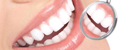 Close-up of white teeth reflected in a dental mirror — Understanding the Different Types of Dental Implant Options