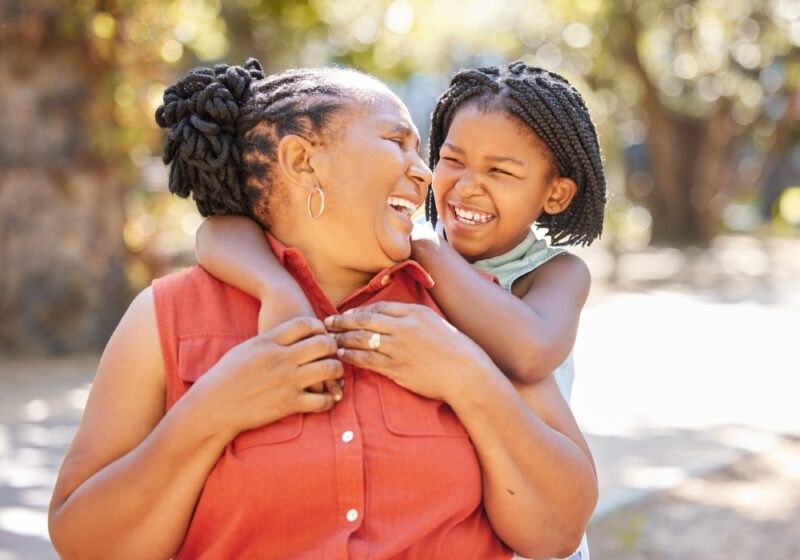 Grandmother and granddaughter hugging and laughing
