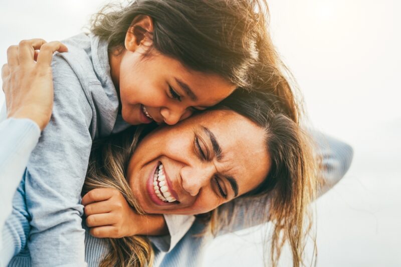 Mother and daughter hugging and laughing