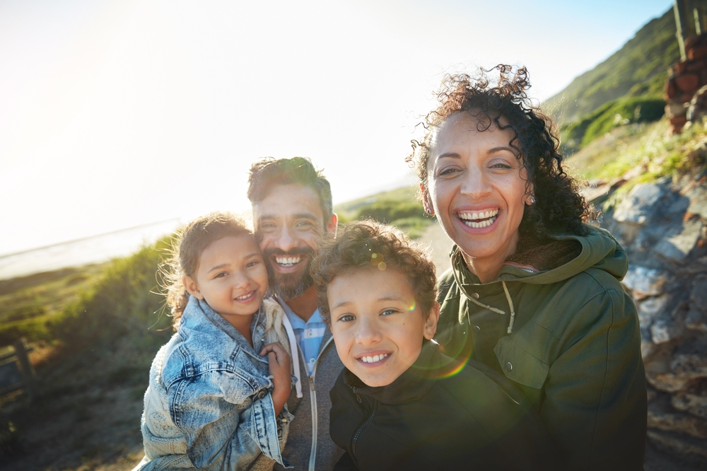 Smiling family taking a selfie on a hillside